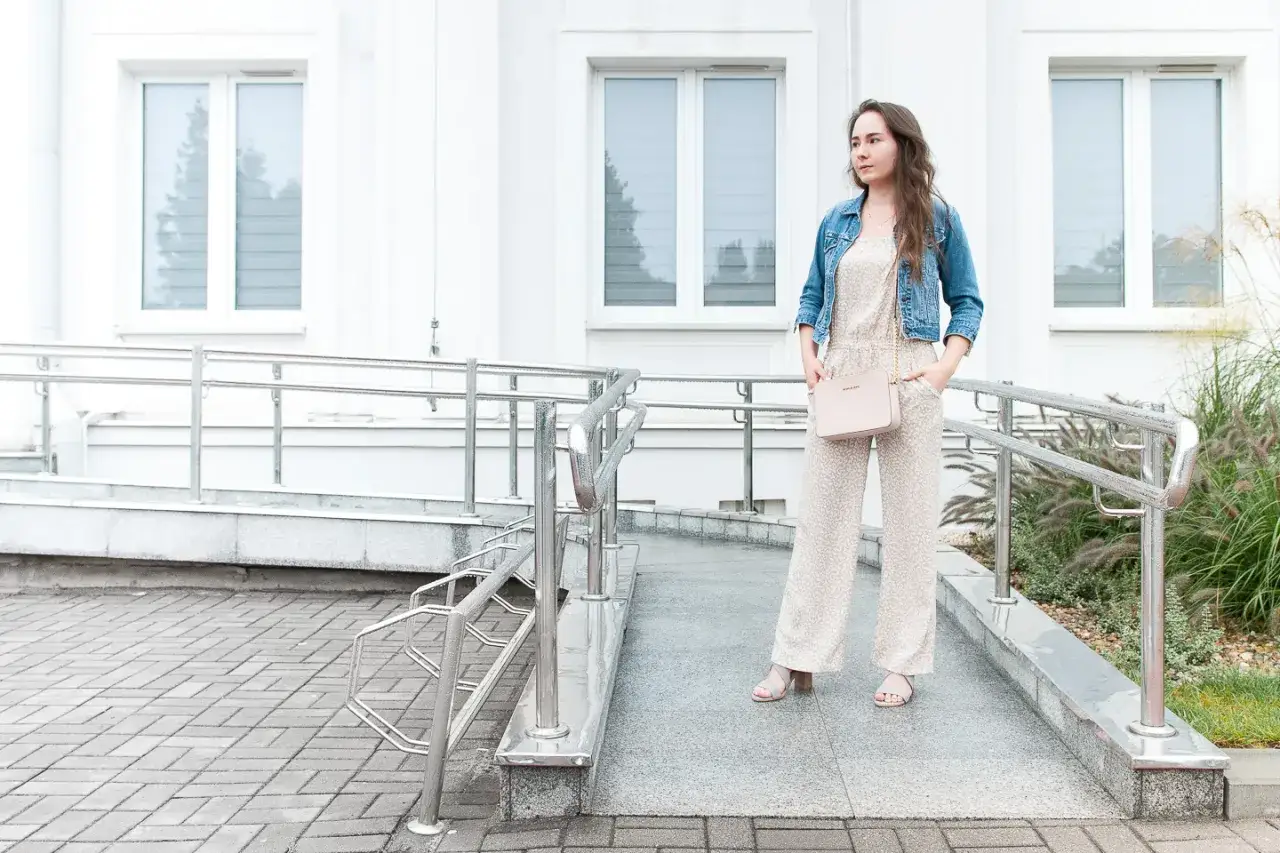 Kobieta w kombinezonie i kurtce jeansowej casual look