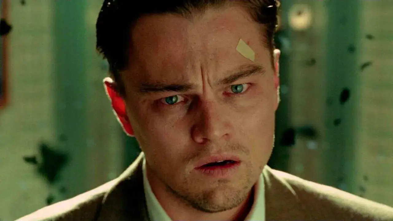 Mężczyzna z plastrem na czole, z przerażeniem w **błyszczących oczach**.