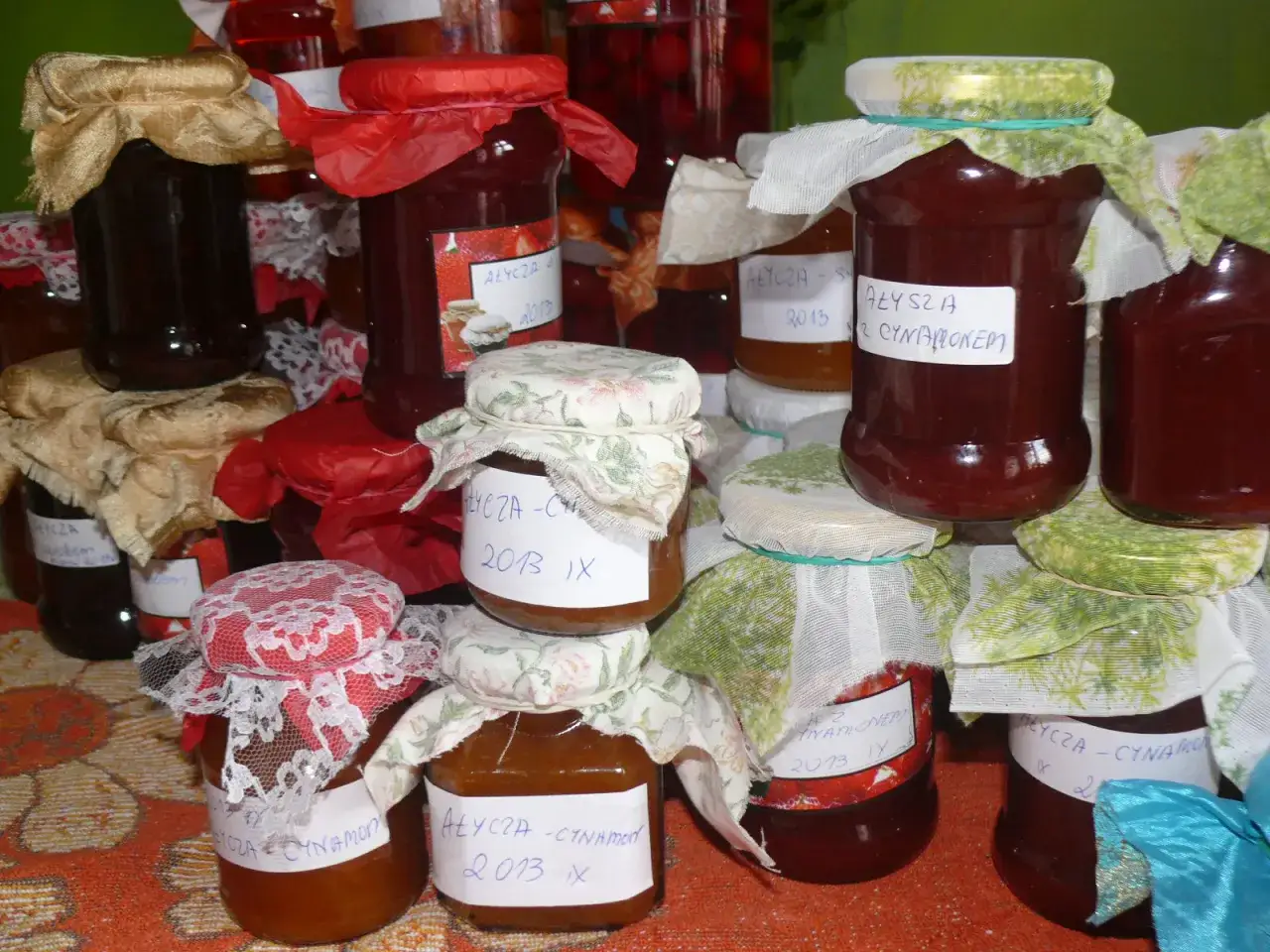 Słoiki z przetworami z wiśni, np. dżem z wiśni czy owoce są jadalne. Widać etykiety z napisem 