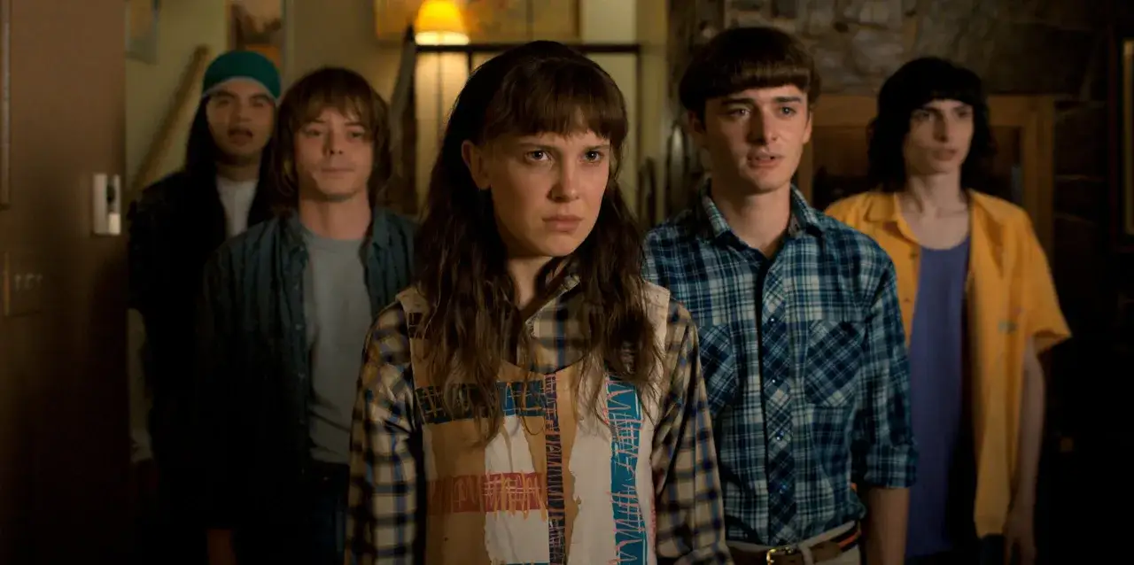 Grupa przyjaciół z serialu Stranger Things, zastanawiająca się, ile zarobił serial.
