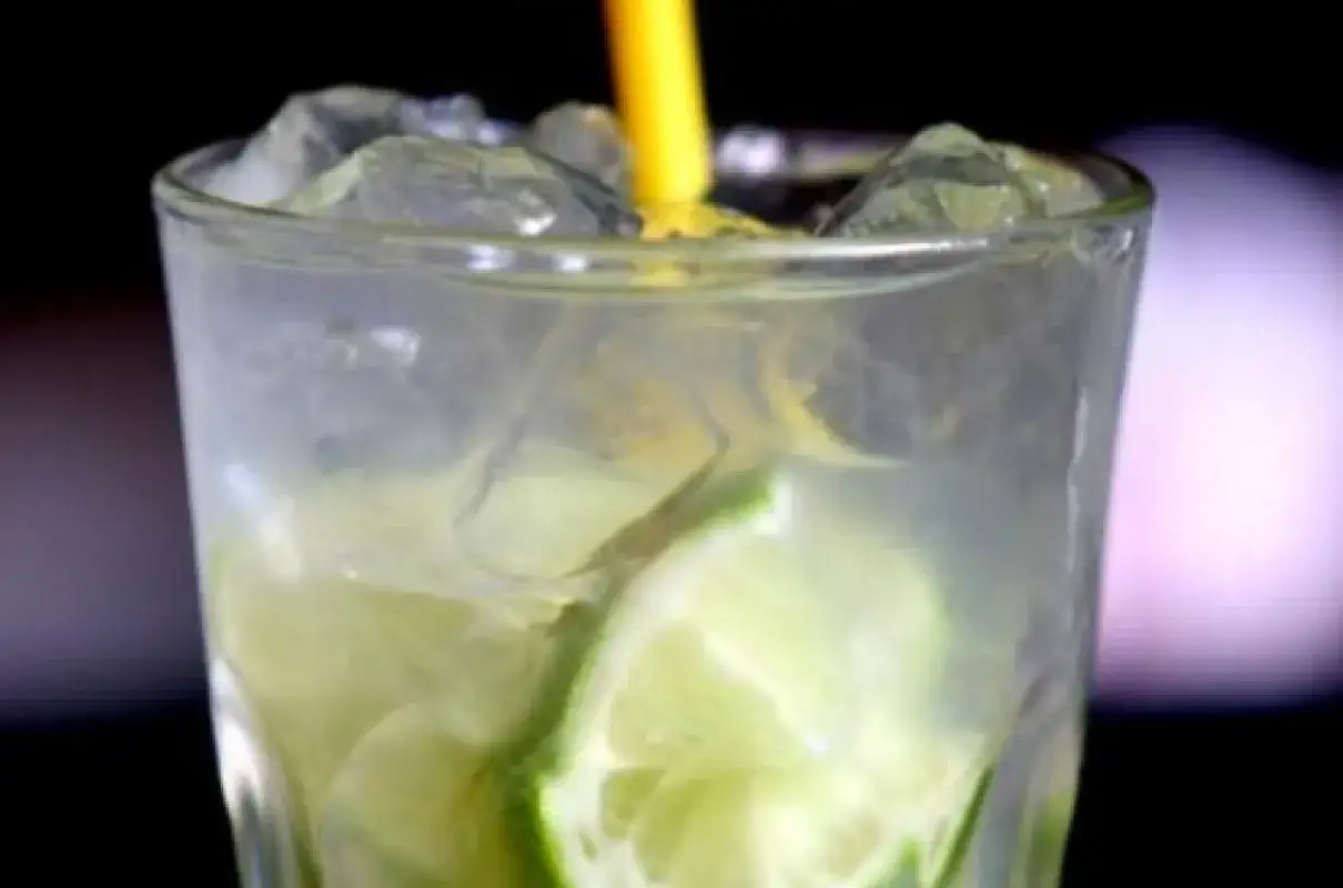 Orzeźwiający gin and tonic z lodem i plasterkami limonki, gotowy do wypicia.