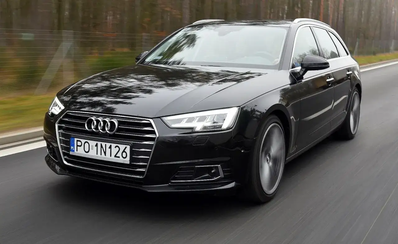 Czarne Audi A4 Avant w ruchu. Zastanawiasz się nad pojemnością baku Audi A4? Ten model oferuje przestronne wnętrze i duży zasięg.