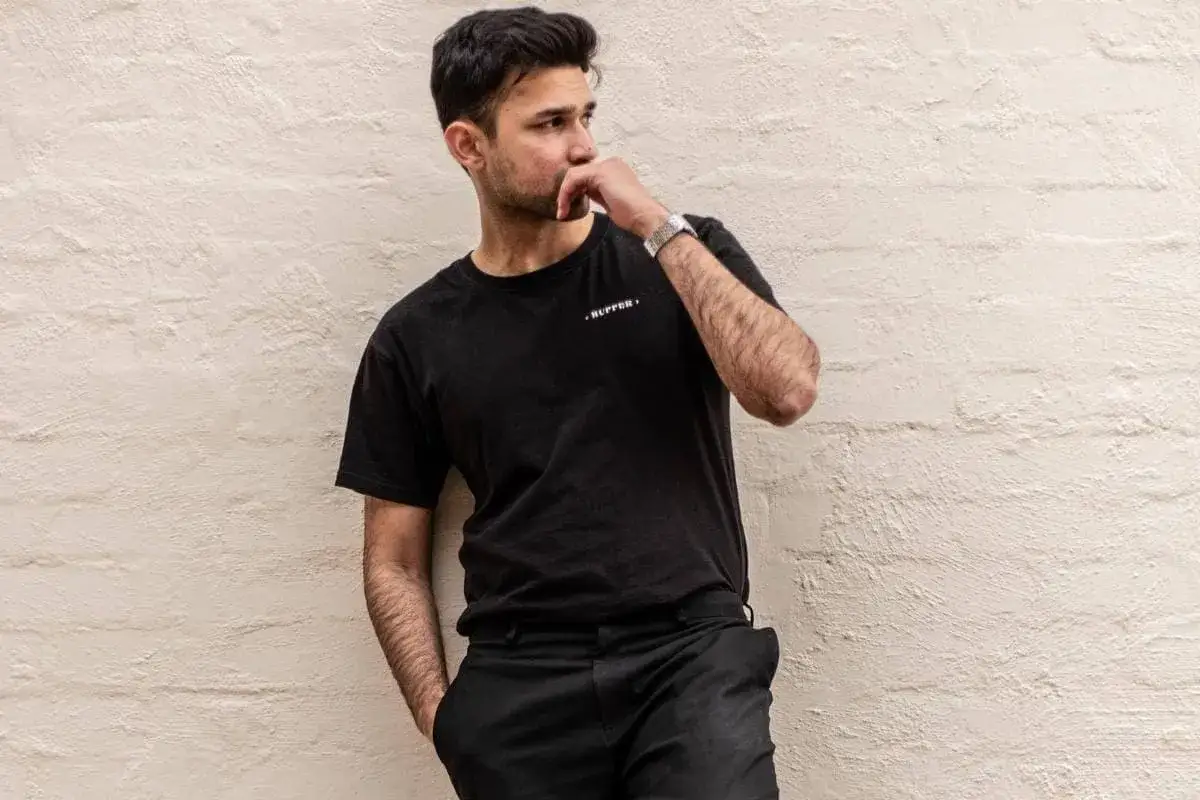 Nieśmiały mężczyzna, gdy widzi kobietę, kt&oacute;ra mu się podoba, odwraca wzrok, lekko się rumieni i bawi się palcami.