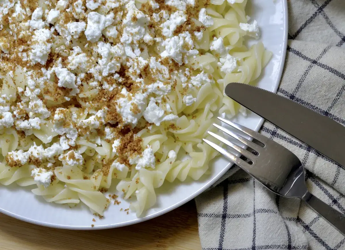Pyszny makaron z twarogiem i bułką tartą, gotowy do jedzenia.