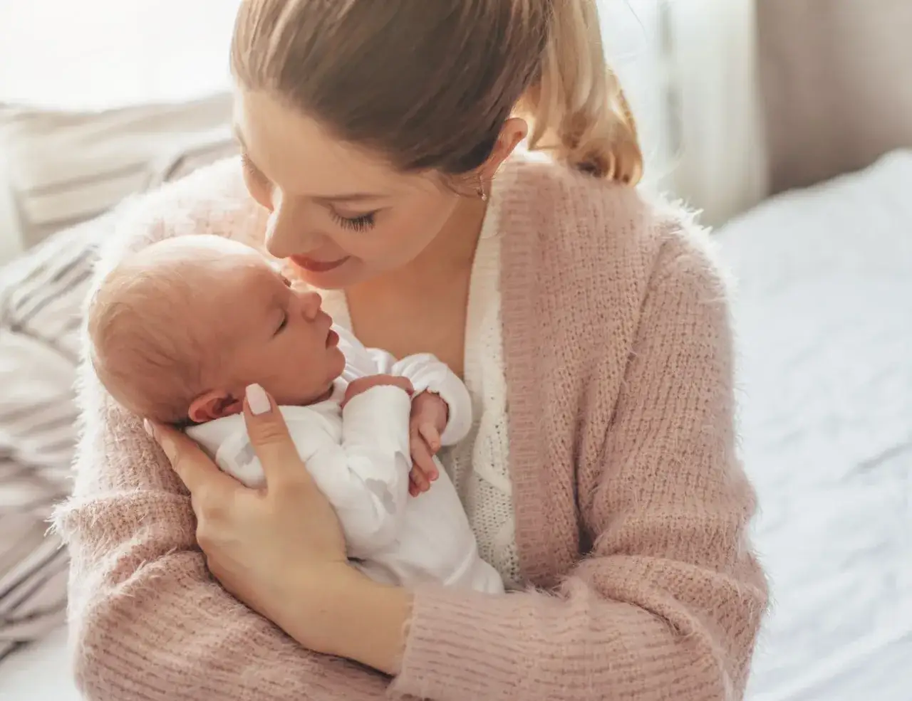 Mama tuli dziecko do piersi na leżąco, a teraz delikatnie je podtrzymuje, przygotowując do odbicia.