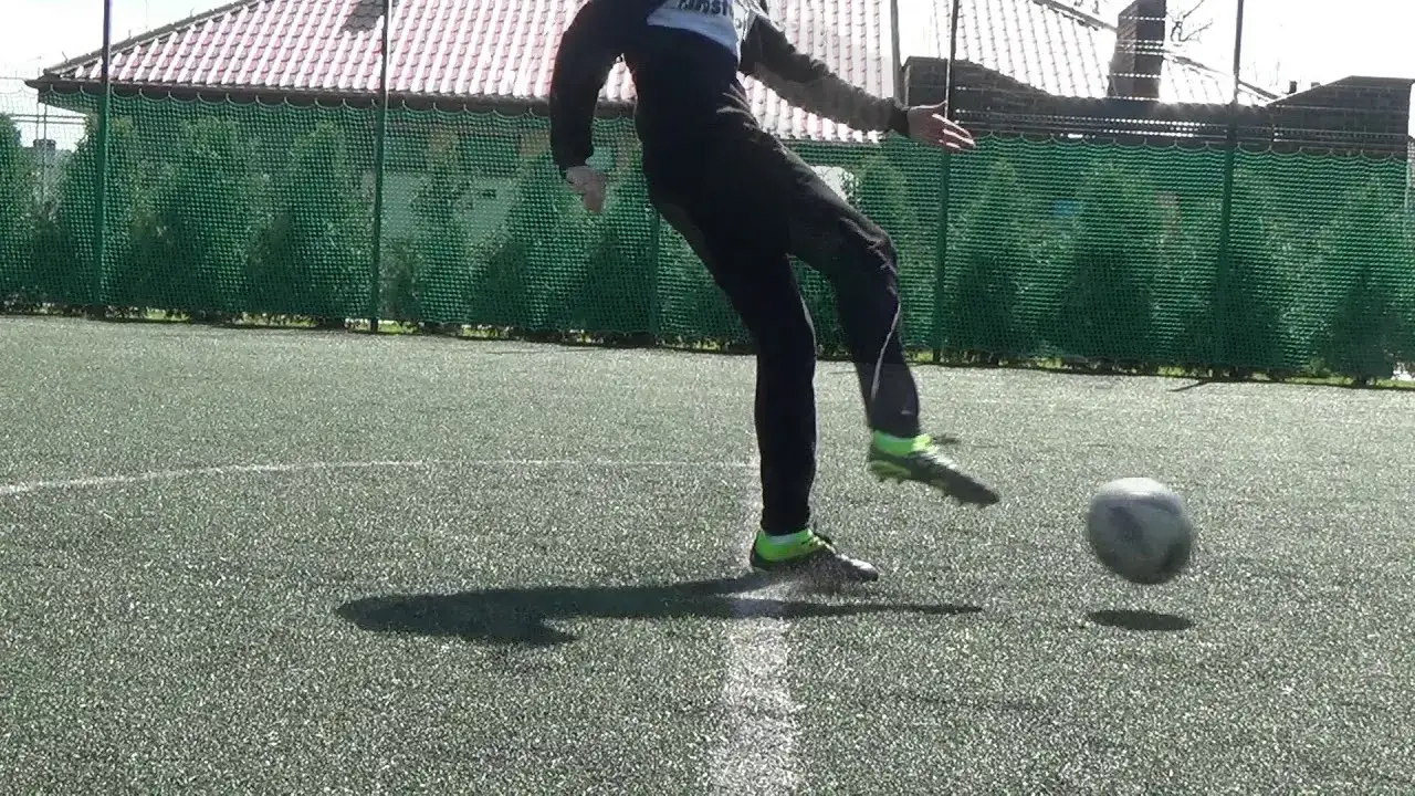 Piłkarz uderzający piłkę prostym podbiciem