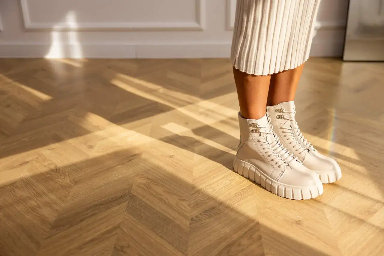 Ciekawe, jakie buty do dzianinowej sukienki? Beżowe trapery na grubej podeszwie świetnie komponują się z jasną, prążkowaną sukienką.