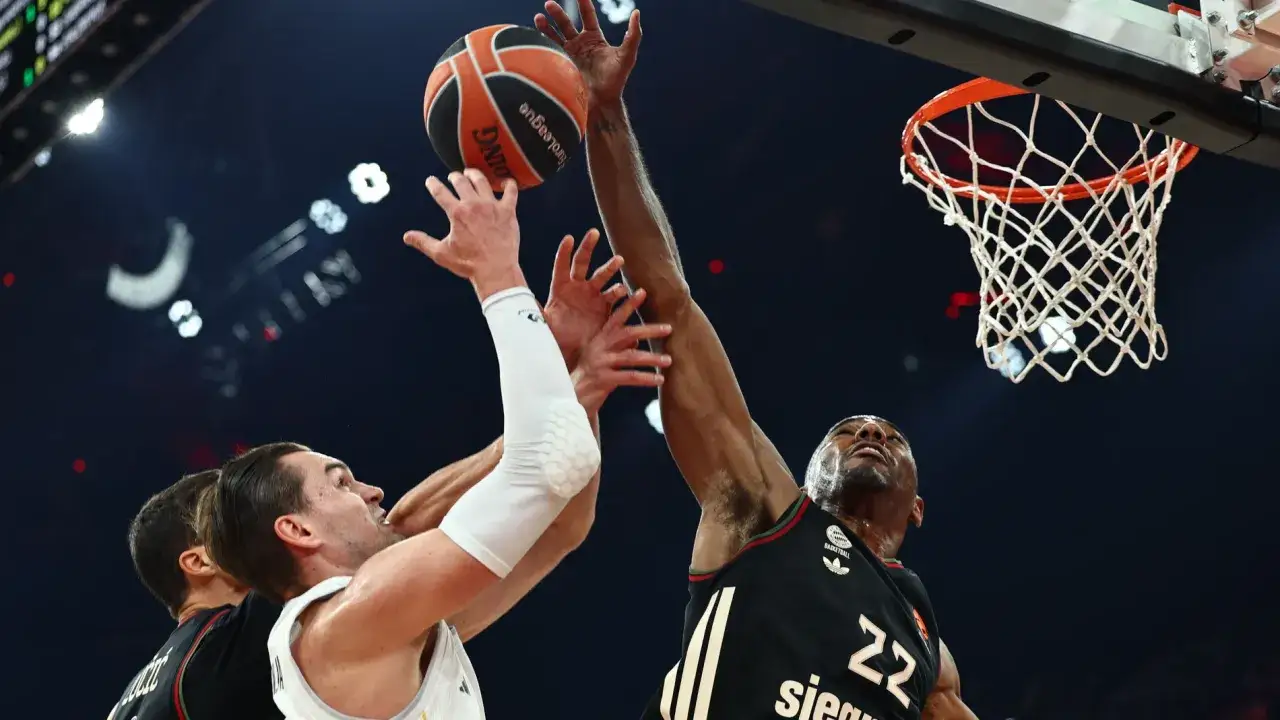 Jugadores de baloncesto del Bayern Munich luchan por el balón cerca de la canasta.