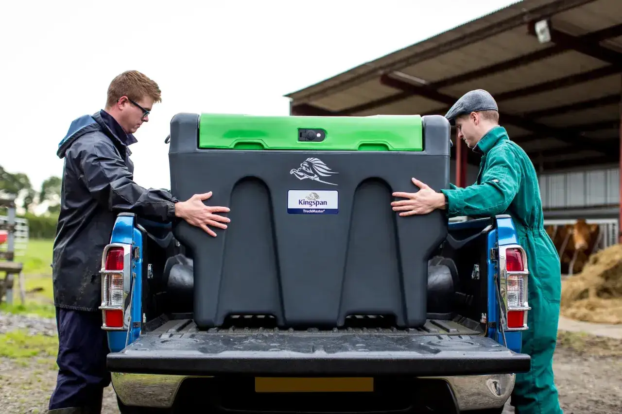 Dwóch mężczyzn ładuje zbiornik na paliwo do pickupa. Zastanawiasz się, ile paliwa można przewieźć przez granicę?