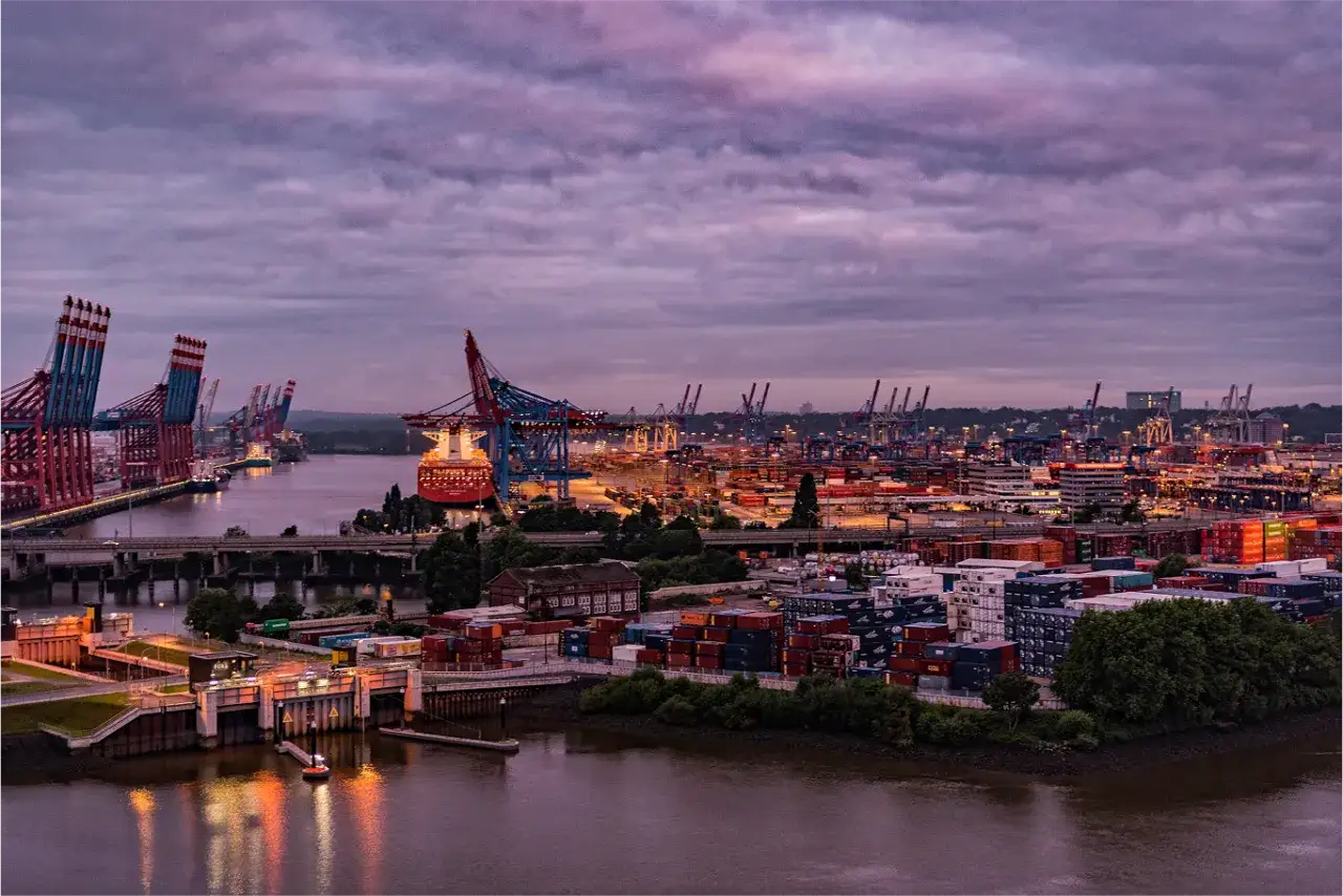 Port w Hamburgu, z ogromnymi dźwigami i kontenerami, pokazuje, że Hamburg leży nad morzem, a dokładniej nad rzeką Łabą, która łączy go z morzem.