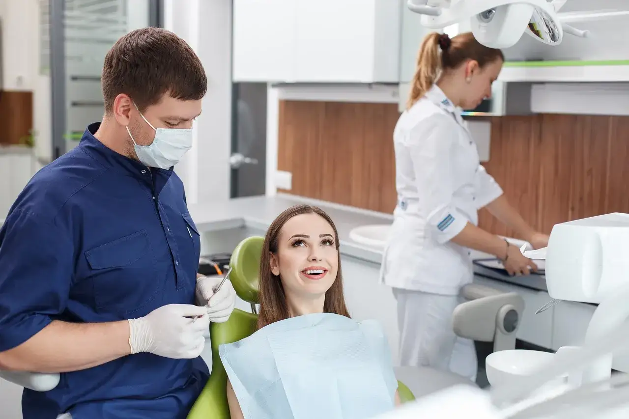 Dentysta i asystentka pracują w gabinecie. Pokazuje, jakie zawody są potrzebne w medycynie.