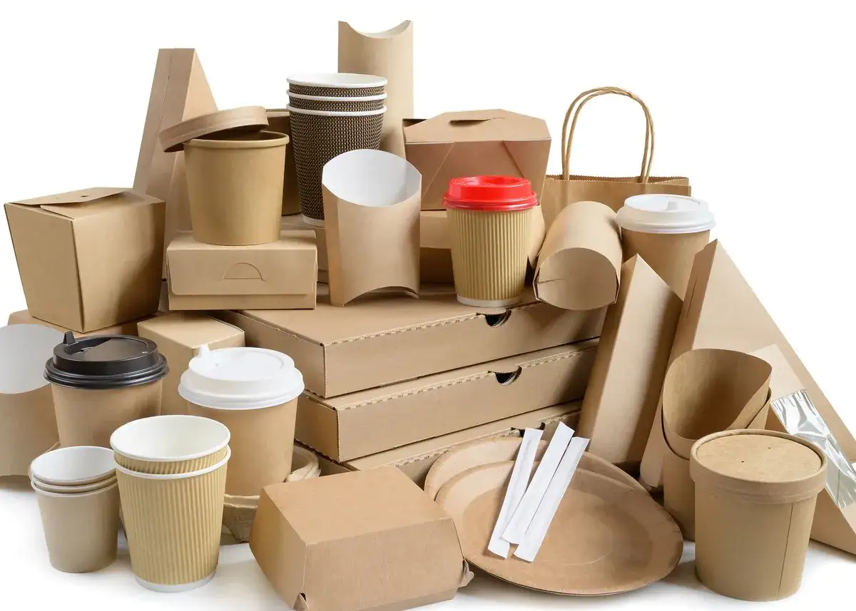 Stos ekologicznych opakowań: kubki, pudełka na wynos, tacki i torby papierowe. Idealne dla gastronomii dbającej o środowisko.