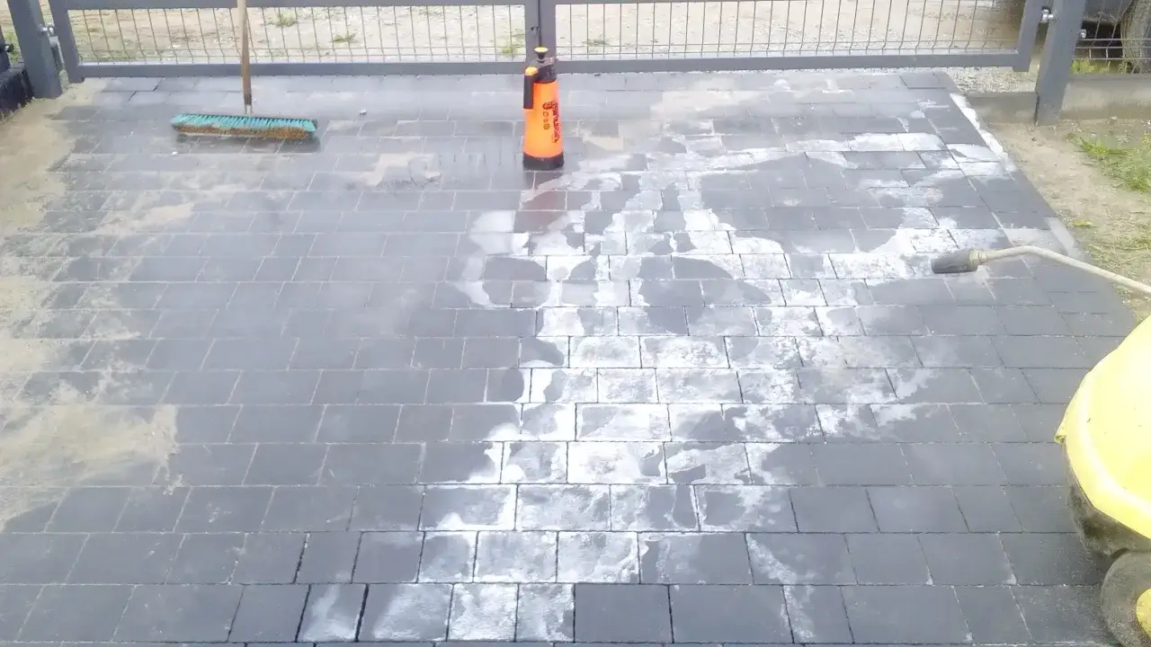 Czyszczenie kostki brukowej: szczotka, opryskiwacz i myjka ciśnieniowa pomagają usunąć glony i brud.