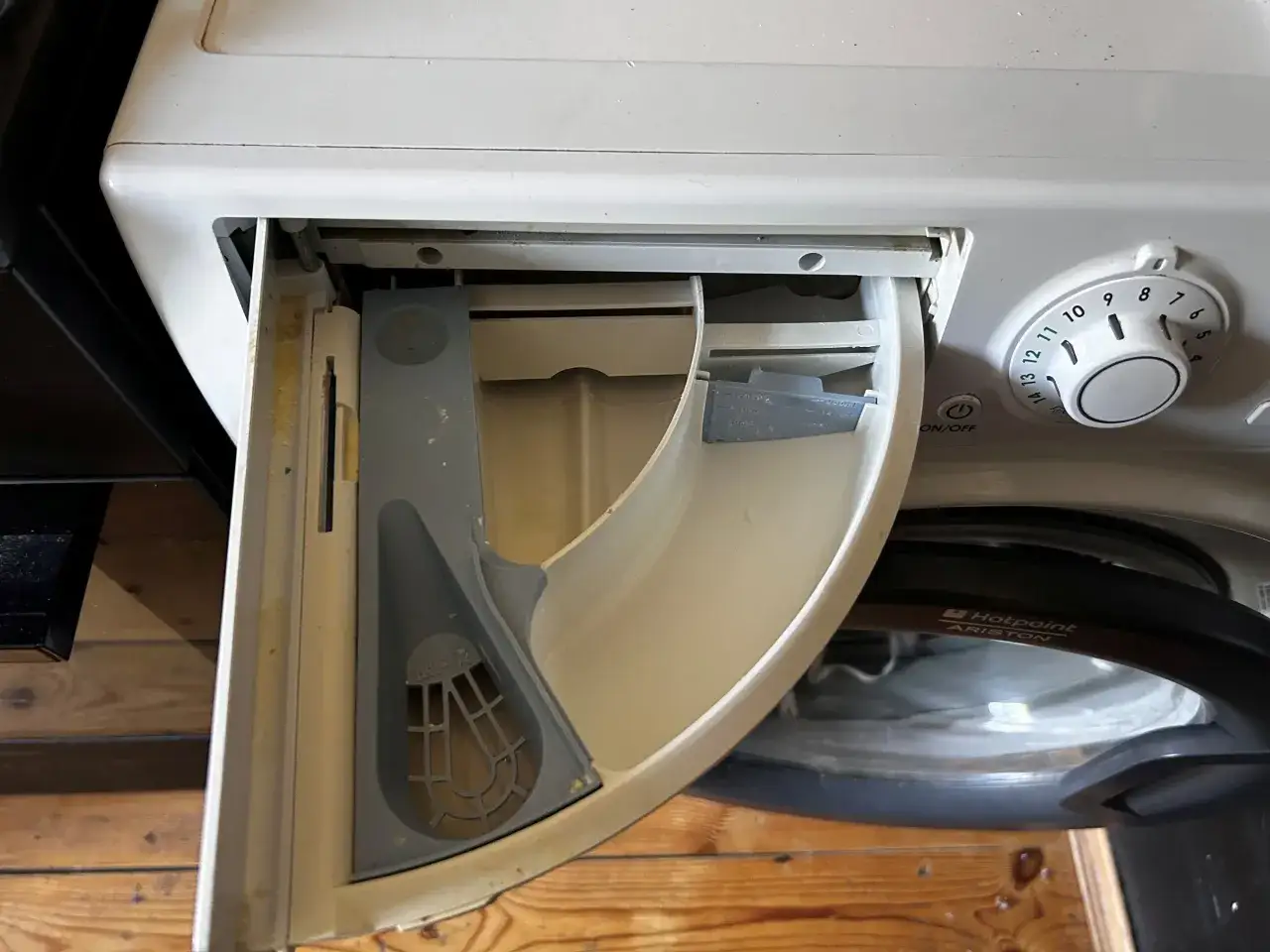 Brudny dozownik proszku i płynu to prawdziwe powody dla których pralka brudzi ubrania ciemnymi plamami po praniu.