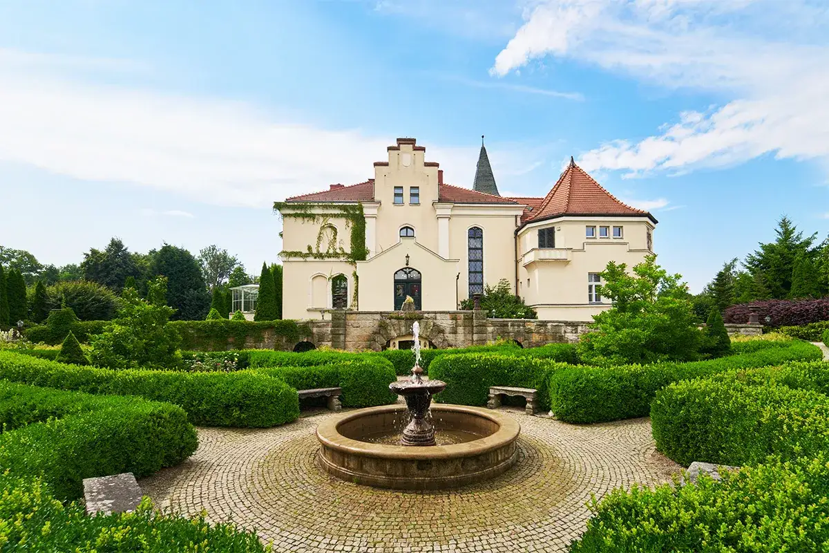 Piękny pałac z ogrodem i fontanną, idealne miejsce na relaks w spa niedaleko Wrocławia.