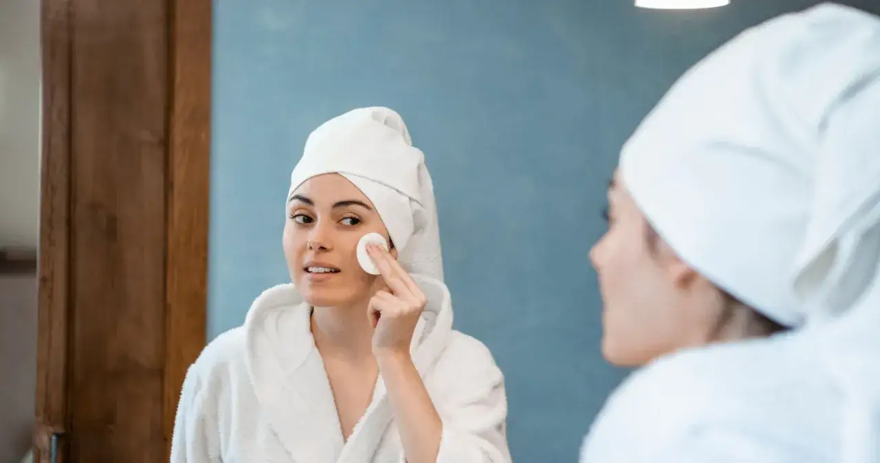 Kobieta aplikująca serum z kapsułki na twarz