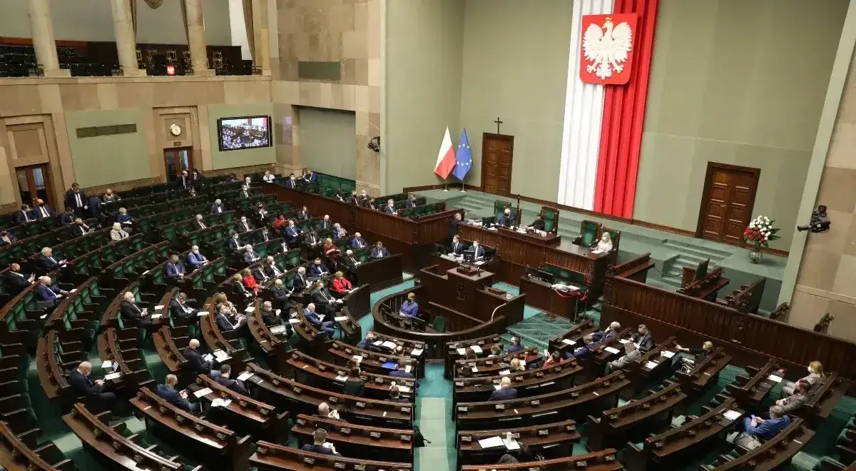 Posiedzenie Sejmu RP. Widoczni politycy po nazwiska, siedzący w ławach i przy mównicy. Flagi Polski i UE.