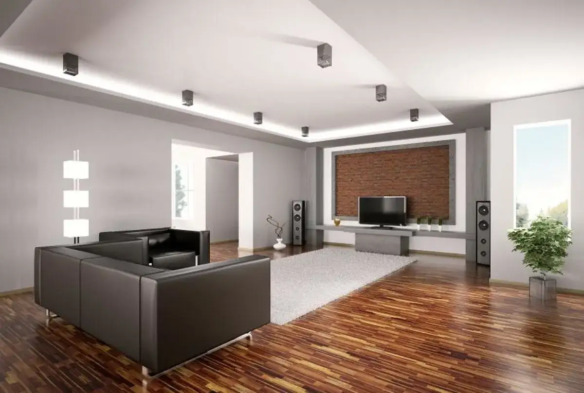 Nowoczesny salon z czarną sofą i błyszczącą, drewnianą podłogą. Zastanawiasz się, czym pomalować starą podłogę drewnianą?