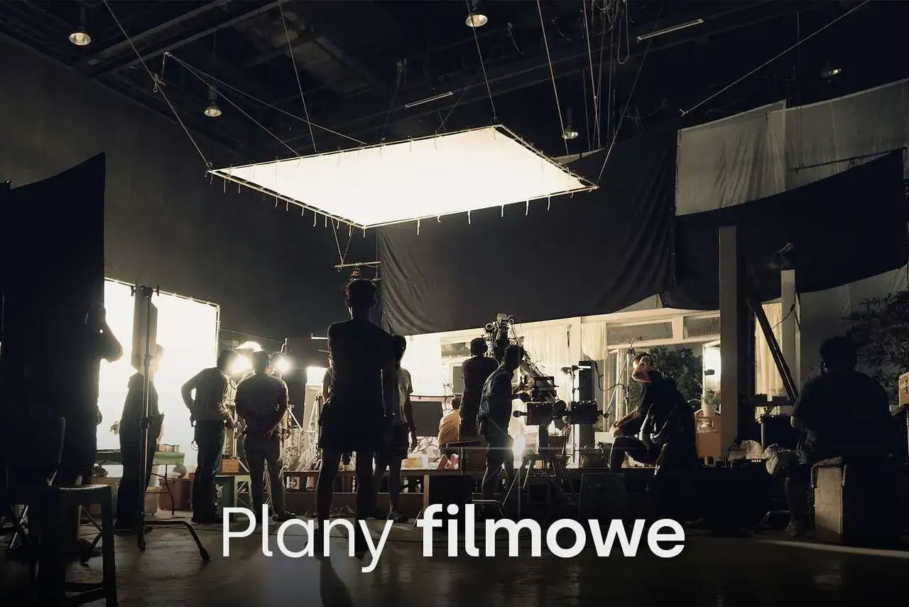 Ekipa filmowa przygotowuje scenę. R&oacute;żne rodzaje oświetlenia i kamery tworzą atmosferę planu filmowego.