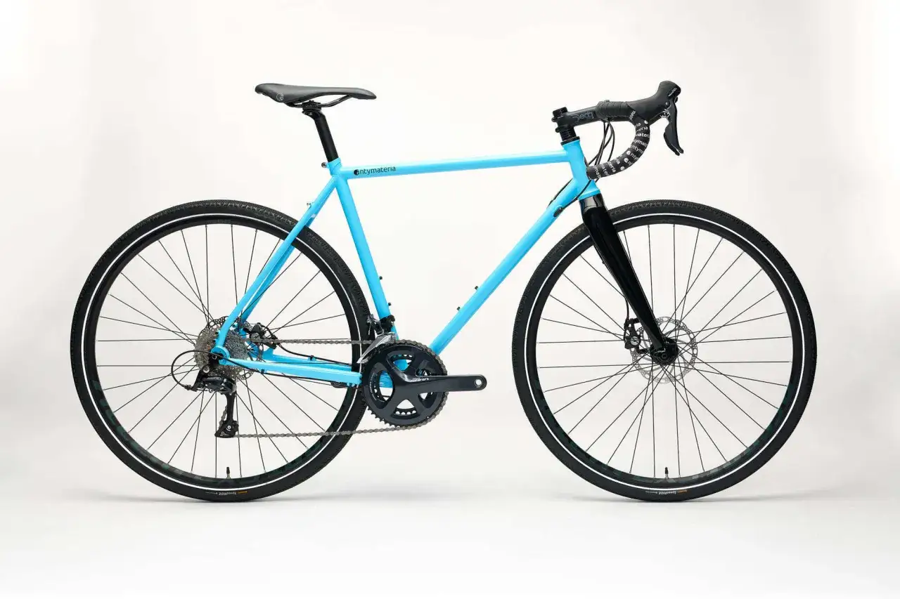 Niebieski rower przełajowy a gravel, gotowy na przygodę po każdej nawierzchni.