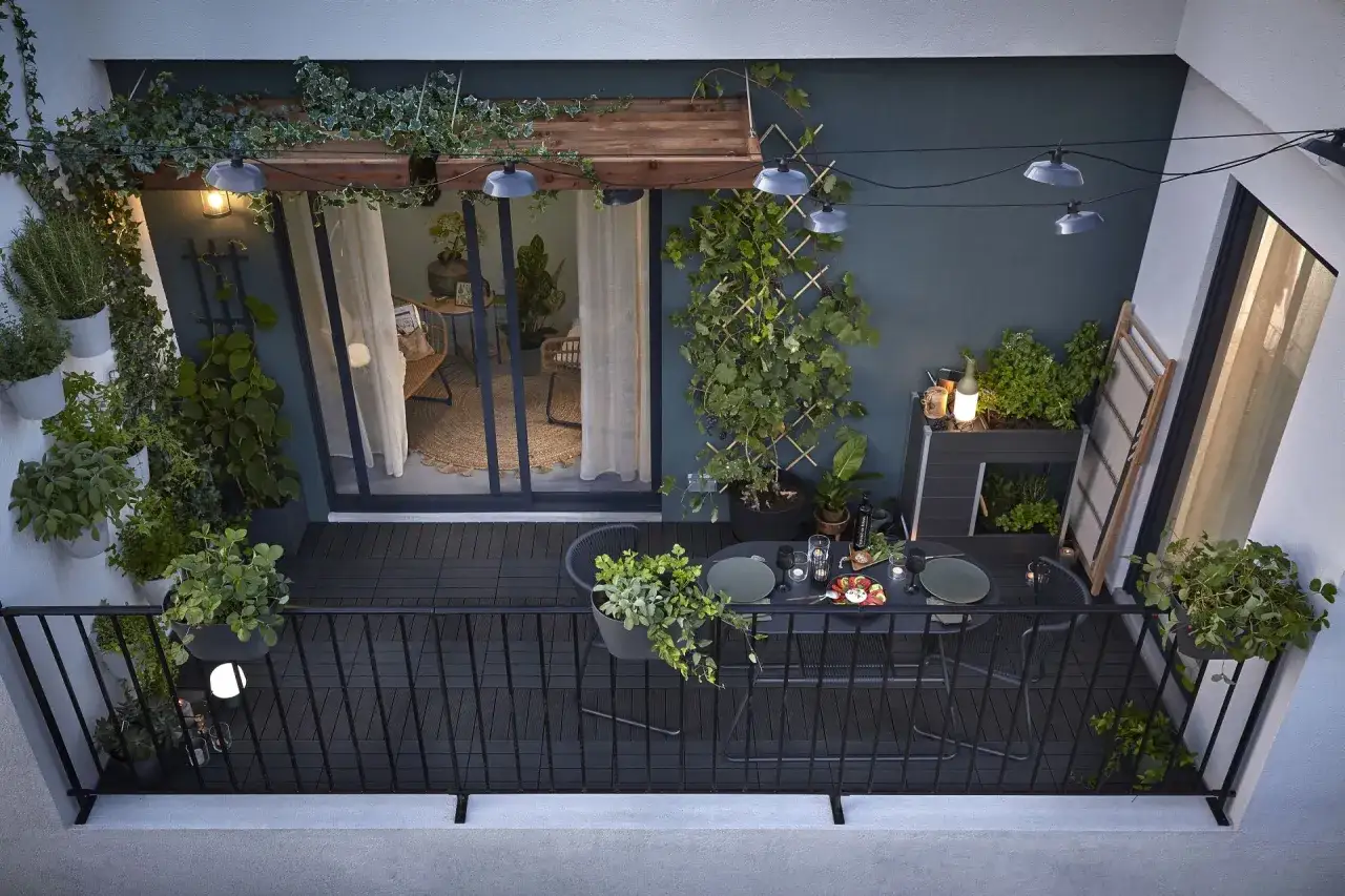 Przytulny mały balkon w bloku, pełen zieleni i światełek. Idealne miejsce na wieczorny relaks.