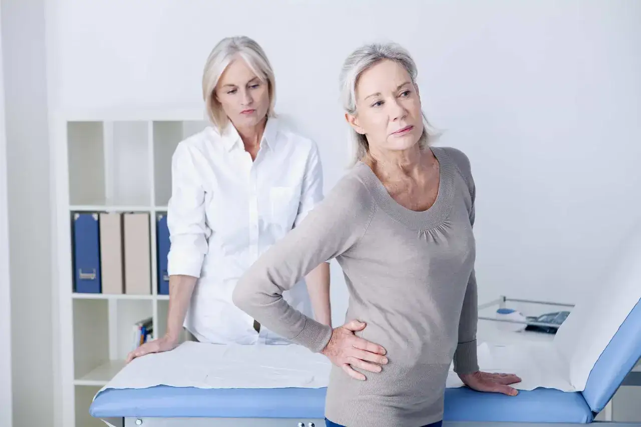 Pacjentka z bólem biodra rozmawia z lekarką. Długo trwa rehabilitacja po endoprotezie stawu biodrowego?