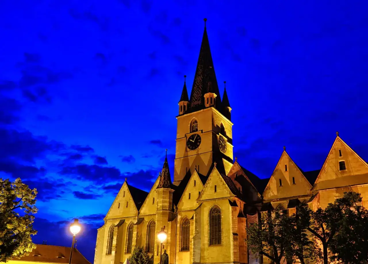 Kościół na starówce w Sybinie nocą, z charakterystyczną wieżą i zegarem. Wspaniałe sybin atrakcje.
