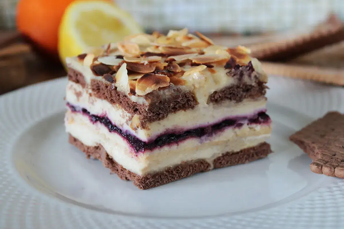 Pyszny deser z warstwami ciemnego biszkoptu, kremu i dżemu, idealny przepis na ciasto z masą chałwową.