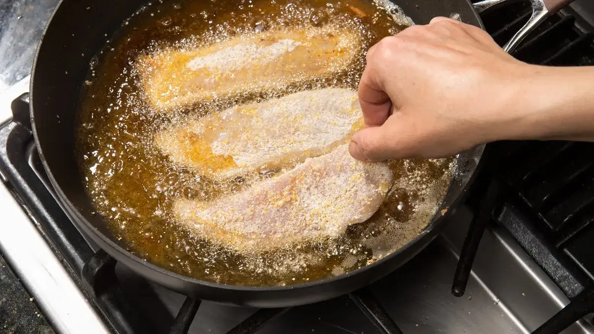 świeża ryba na patelni przed smażeniem z solą