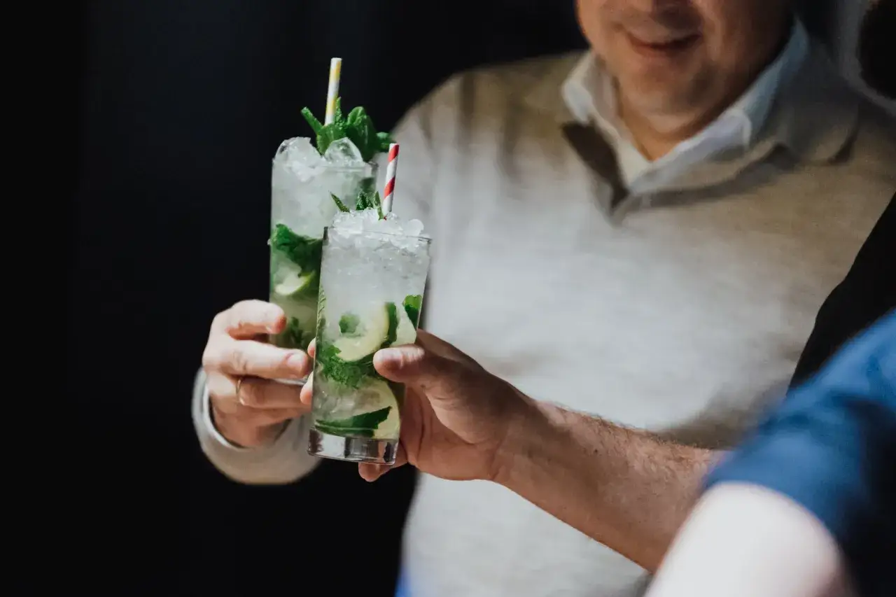 Dwie szklanki orzeźwiającego mojito drink ze spritem, ozdobione miętą i limonką, gotowe do toastu.