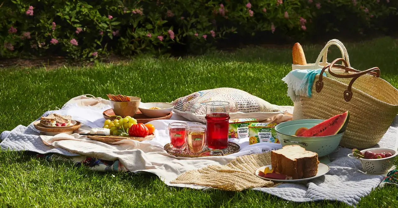 Idealne przekąski na piknik: kanapki, owoce, napoje i kosze pełne smakołyków na trawie.