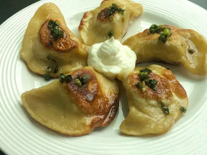 shoe polish next to a plate of Polish pierogi with labels