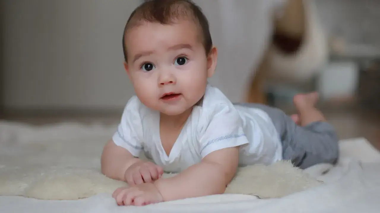 Uroczy niemowlak na brzuchu, być może przeżywa skok rozwojowy 6 tydzień objawy.