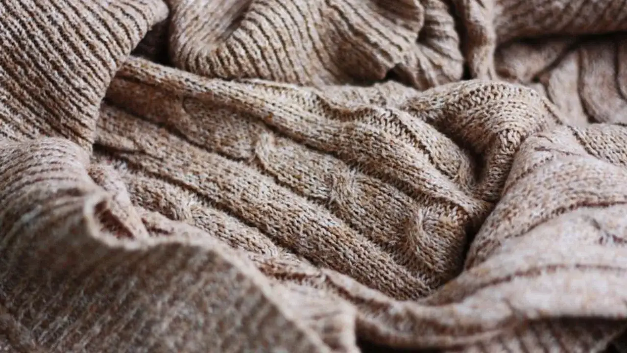 Brązowy, gruby sweter z warkoczowym splotem. Idealny, by dowiedzieć się, jak skurczyć wełnę i uzyskać przytulny efekt.