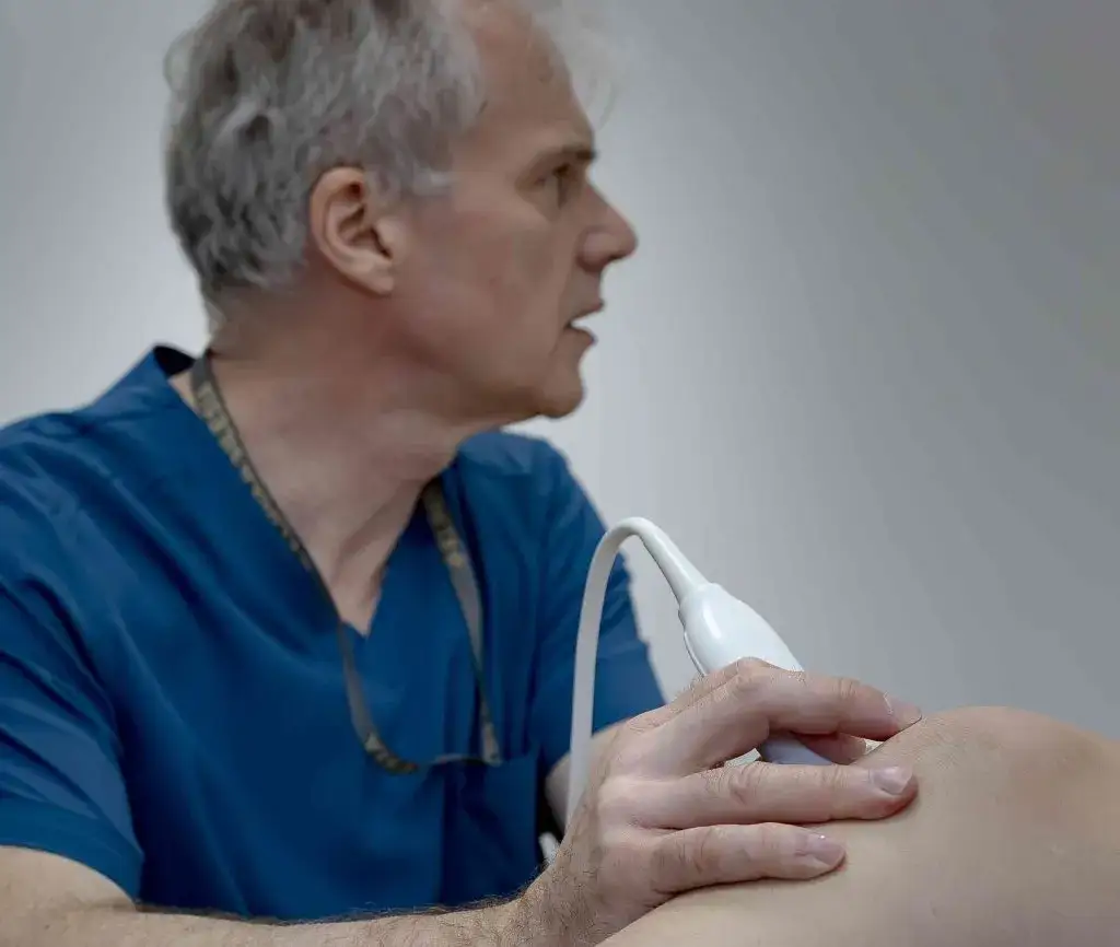 Ortopeda diagnozujący pacjenta z bólem kolana