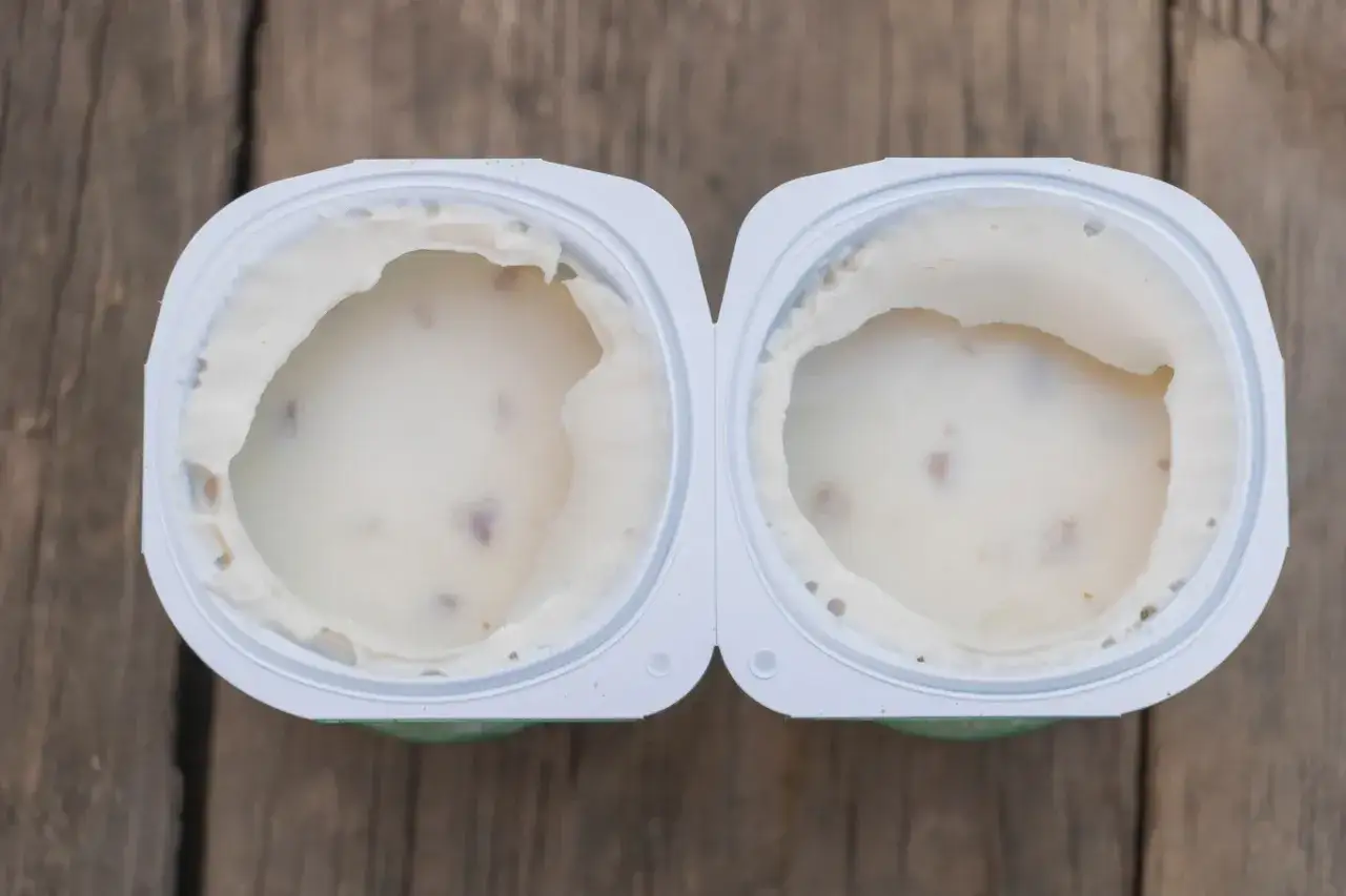 Dwa pojemniki z jogurtem, z widocznymi kawałkami owoców. Pytanie brzmi: czy można jeść zważony jogurt?