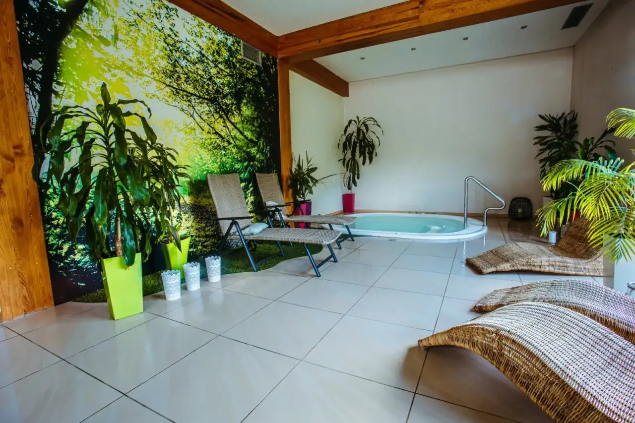 Relaks w spa Kazimierz Dolny: jacuzzi, leżaki i bujna zieleń tworzą oazę spokoju.