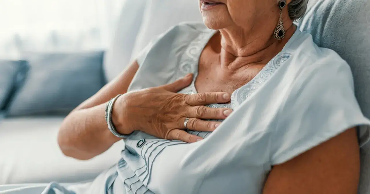 Starsza kobieta trzyma się za klatkę piersiową, czując pieczenie. Opowiada, jak wyleczyłem refluks, odzyskując spok&oacute;j.