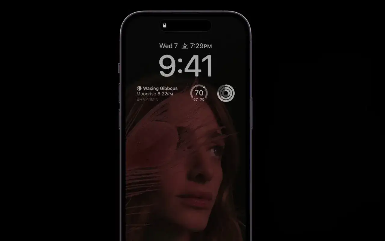Ekran blokady iPhone 14 z datą, godziną i zdjęciem kobiety. Czy oplaca sie kupic iPhone 14?