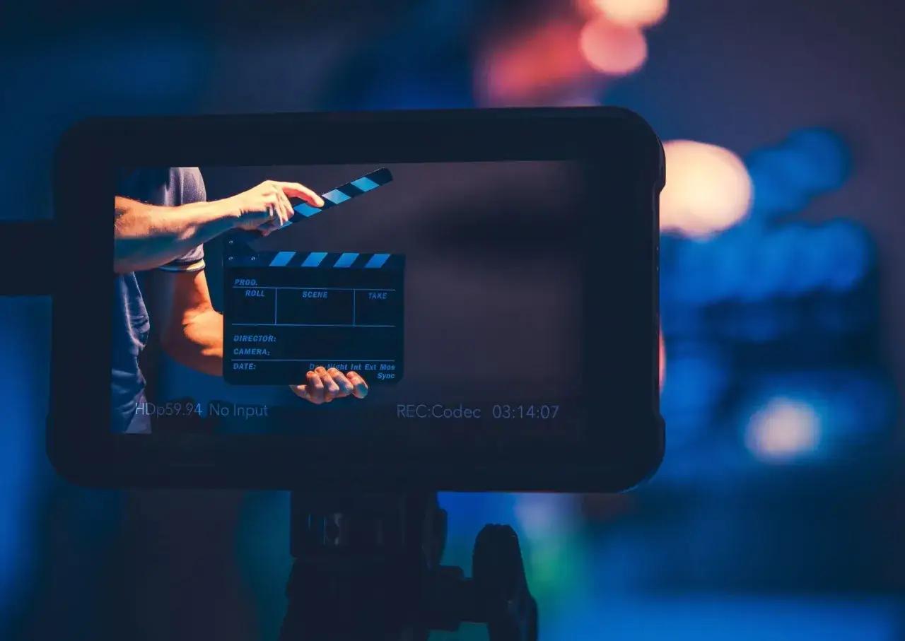 Ręka zamyka klaps filmowy na planie. R&oacute;żne plany filmowe rodzaje są kluczowe dla tworzenia historii.