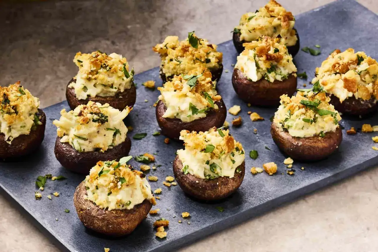 Pyszne dania na imprezę na ciepło: pieczarki faszerowane kremowym farszem i chrupiącą posypką. Idealne na każdą okazję.