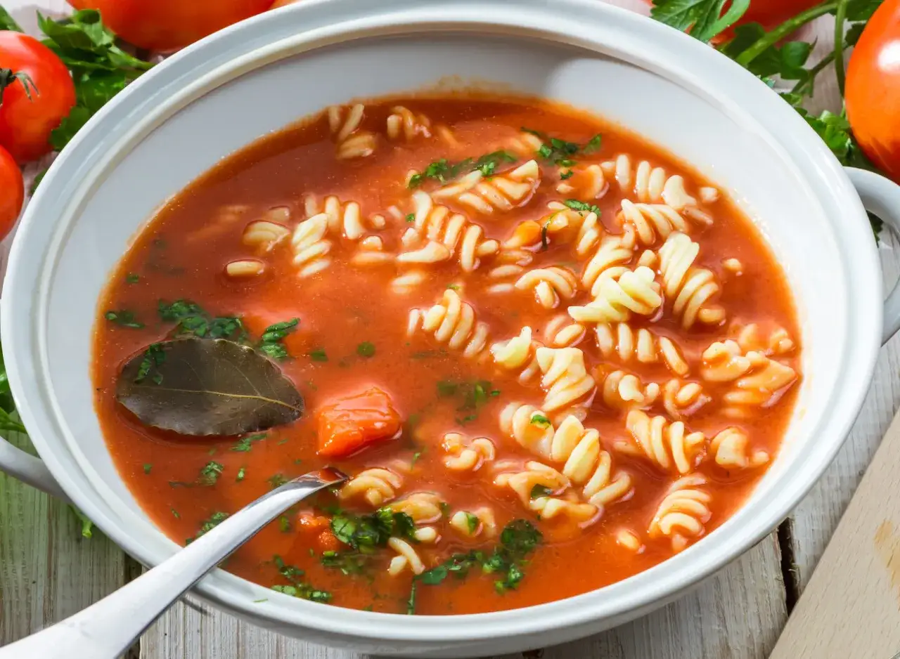 Aksamitna zupa pomidorowa z makaronem fusilli, listkiem laurowym i natką pietruszki. Idealna do doprawienia ziołami.