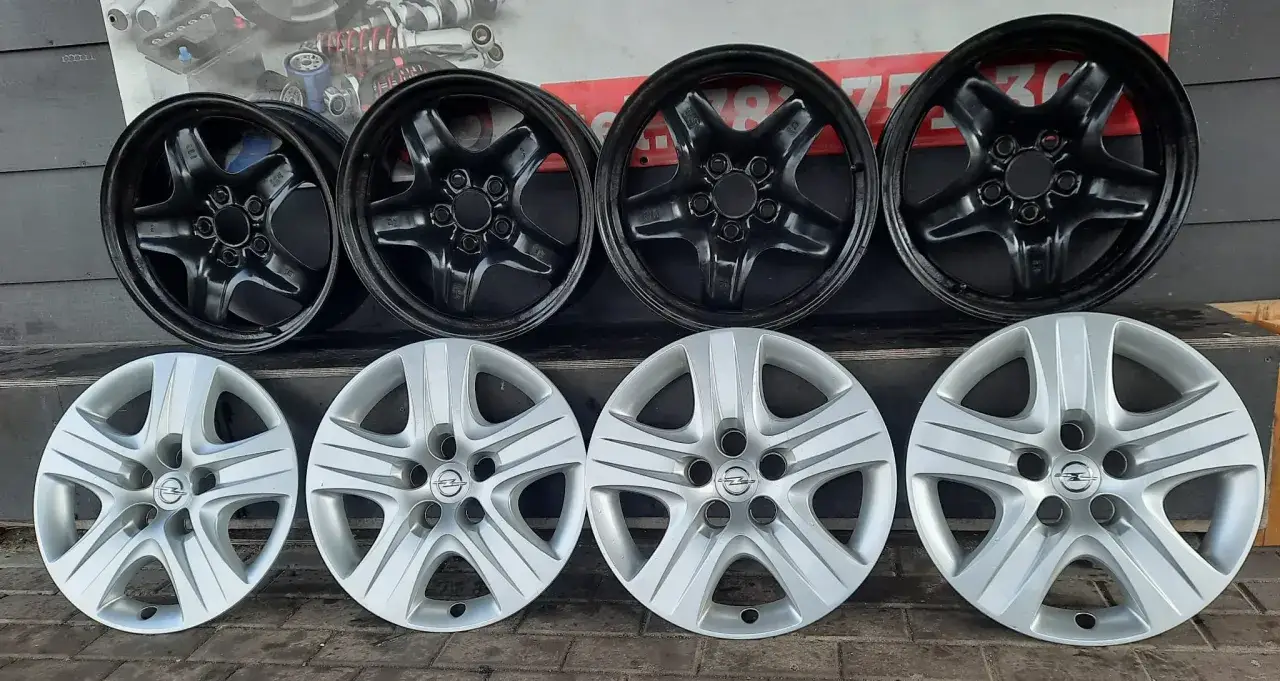 Dwa zestawy felg: czarne, pięcioramienne felgi strukturalne Opel i srebrne, pięcioramienne felgi Opel.