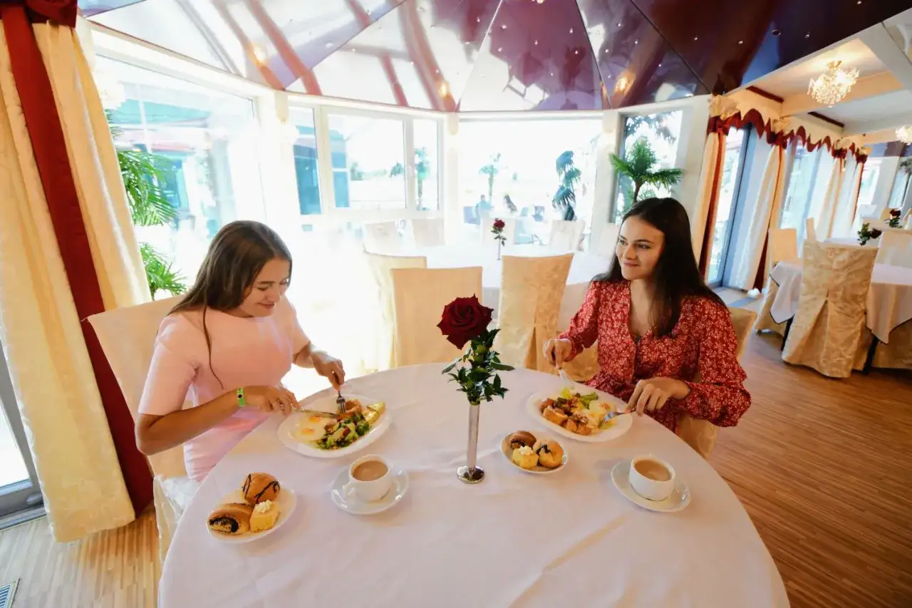 Dwie dziewczyny jedzą śniadanie w hotelowej restauracji. Czy można zamówić jedzenie do hotelu? Tak, to idealne miejsce na posiłek.