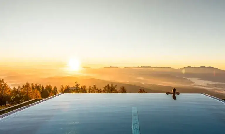Infinity Pool mit Bergblick in den Alpen bei Sonnenuntergang