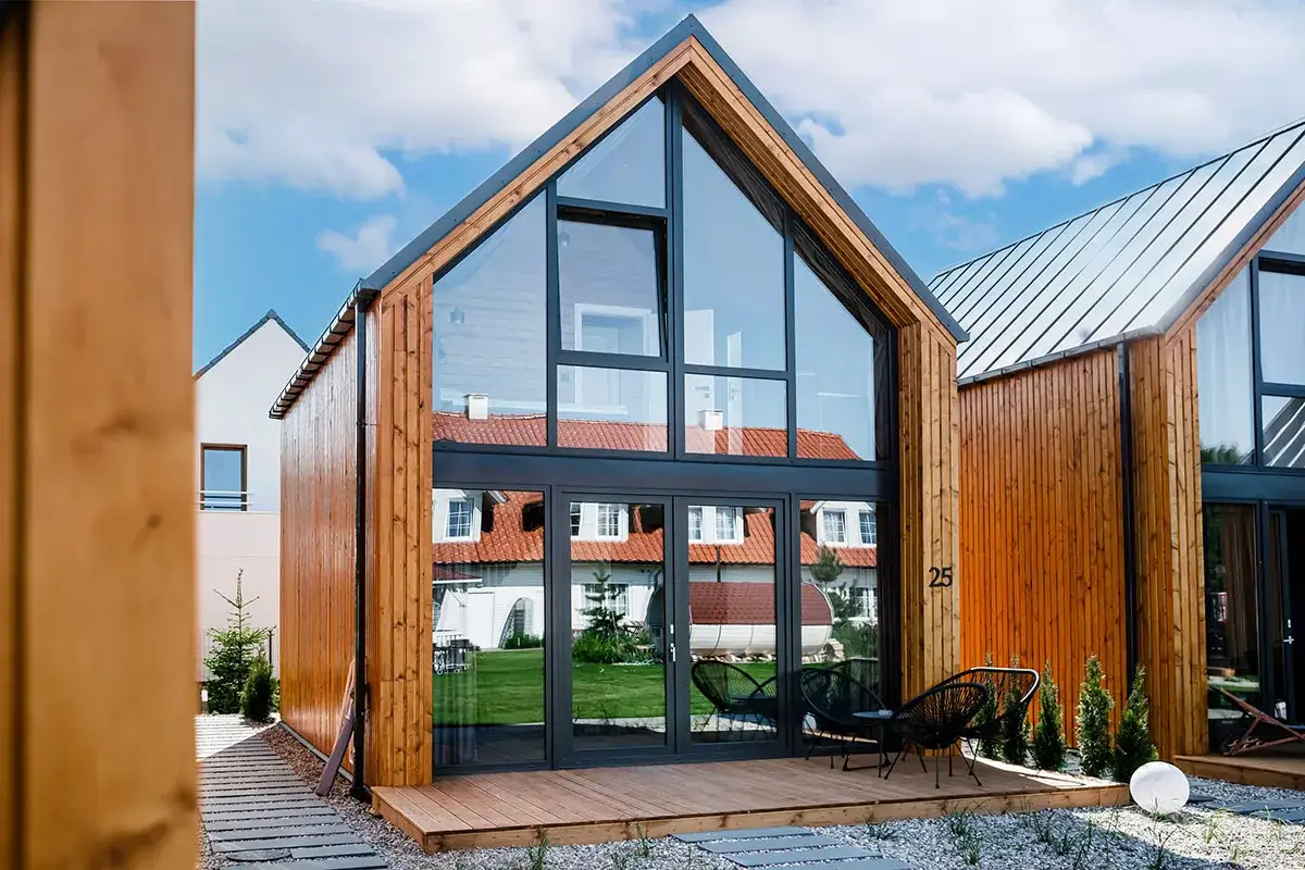 Nowoczesne domki letniskowe całoroczne z dużymi przeszkleniami. Zastanawiasz się, ile kosztuje budowa domku letniskowego całorocznego?