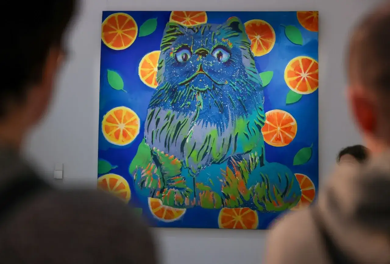 Kolorowy kot wśr&oacute;d pomarańczy na obrazie w muzeum sztuki Wrocław.