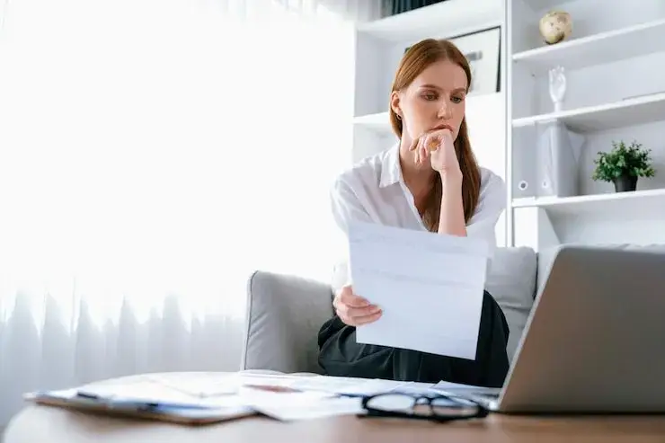 smutna osoba analizująca dokumenty finansowe w domu