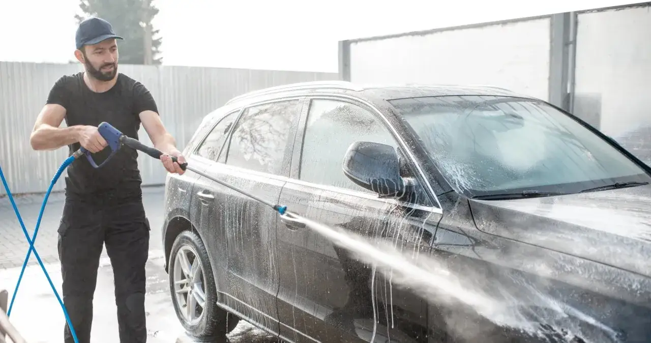 Osoba używająca lancy w myjni bezdotykowej BP
