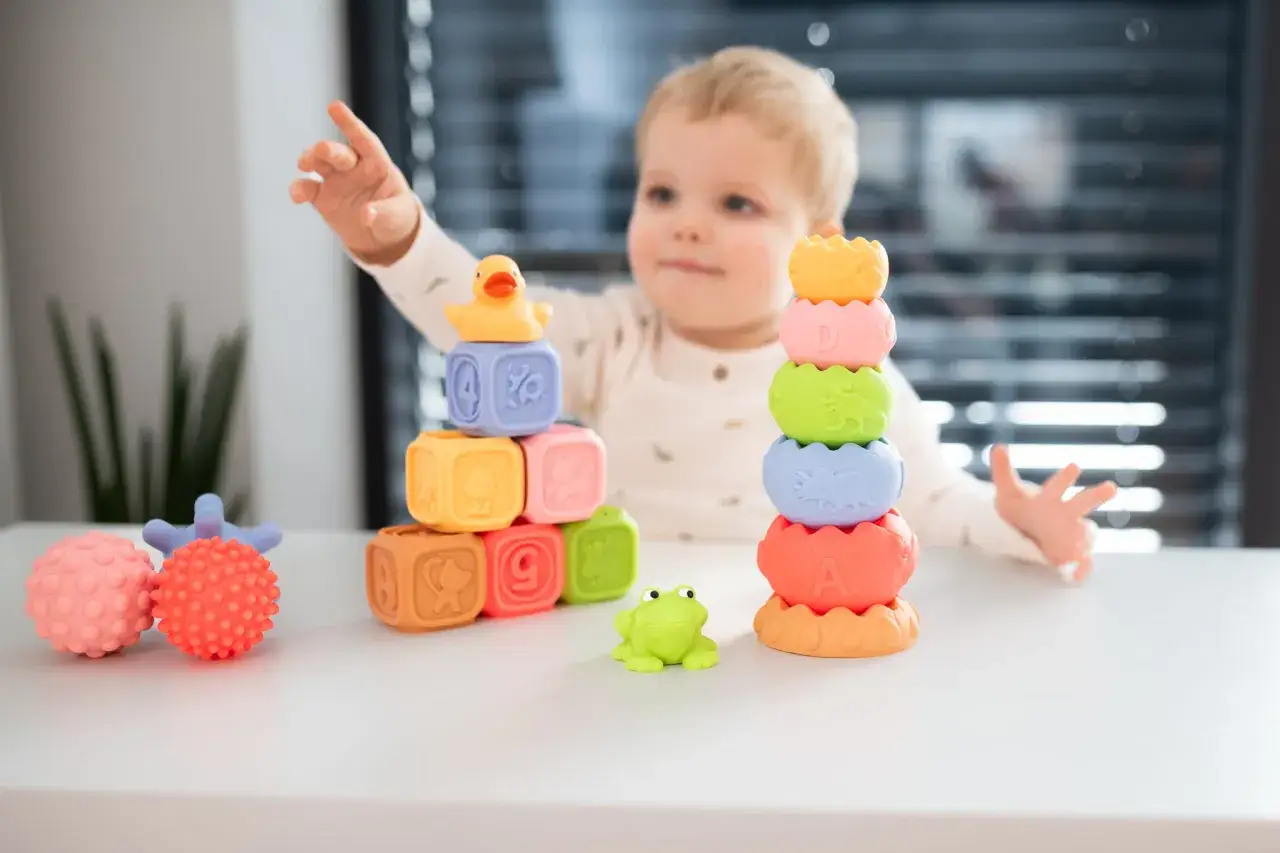 Dziecko odkrywa faktury i kolory klock&oacute;w sensorycznych